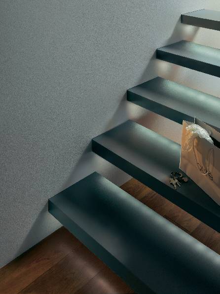 Een moderne, witte trap met een glazen leuning en houten vloer. Op de achtergrond zijn zachte lichtstralen zichtbaar.