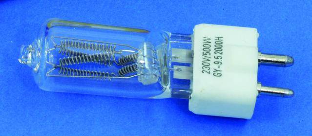 Een halogeenlamp met de opdruk '230V 500W GY-9.5 2000H', liggend op een blauwe achtergrond, toont de binnenste gloeidraad.