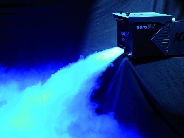 Een rookmachine produceert blauwe rook die zacht in de omgeving stroomt. Deze creëert een atmosferische lichteffect-achtergrond.