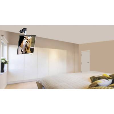 Een slaapkamer met een bed op de voorgrond. Een televisie is aan het plafond bevestigd, waarop een film met een beer wordt vertoond.