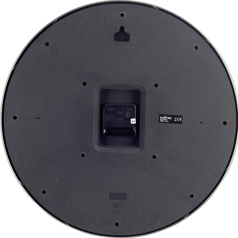 'Achterkant van een zwarte wandklok met batterijvak in het midden. Merklogo en CE-markering zichtbaar.'
