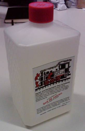 Heldere kunststof fles met een rode schroefdop, etiket toont 'SR24 modelspoorolie', naast een afbeelding van een stoomlocomotief.