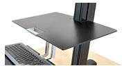 Een in hoogte verstelbaar bureau met een zwart werkblad en een toetsenbord erop, geschikt voor ergonomisch werken.