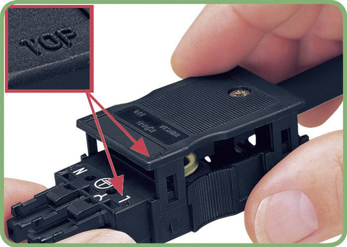 Een persoon verbindt twee zwarte kunststofcomponenten. Op het onderdeel staat 'TOP', om de juiste oriëntatie aan te geven.