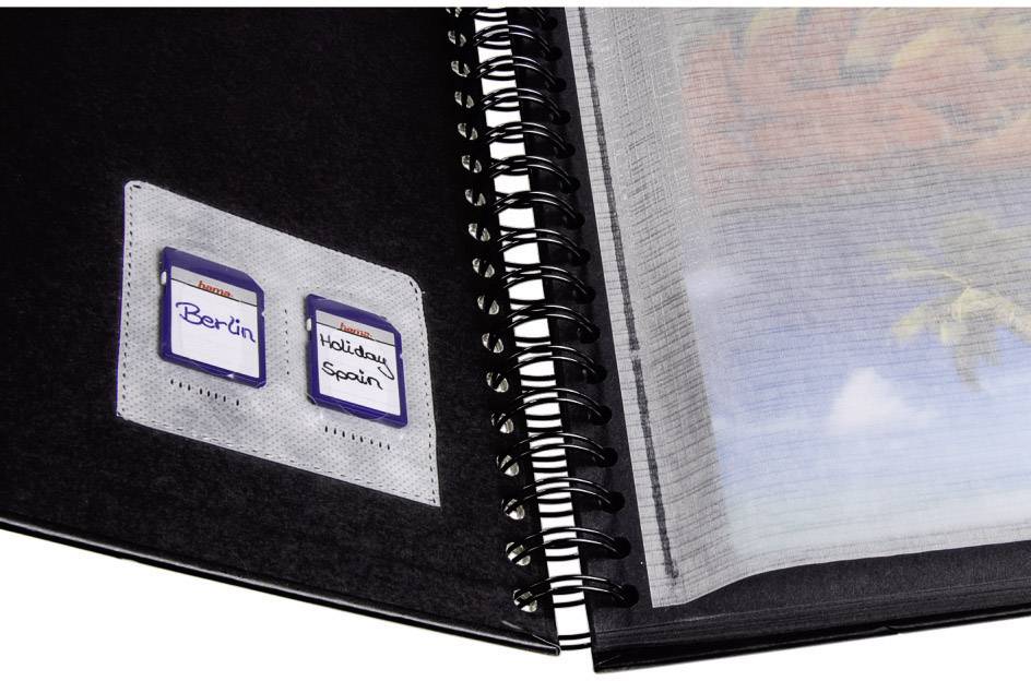 Notitieboek met spiraalbinding, opengeslagen pagina toont twee beschreven stickers: 'Berlijn' en 'Vakantie Spanje'.