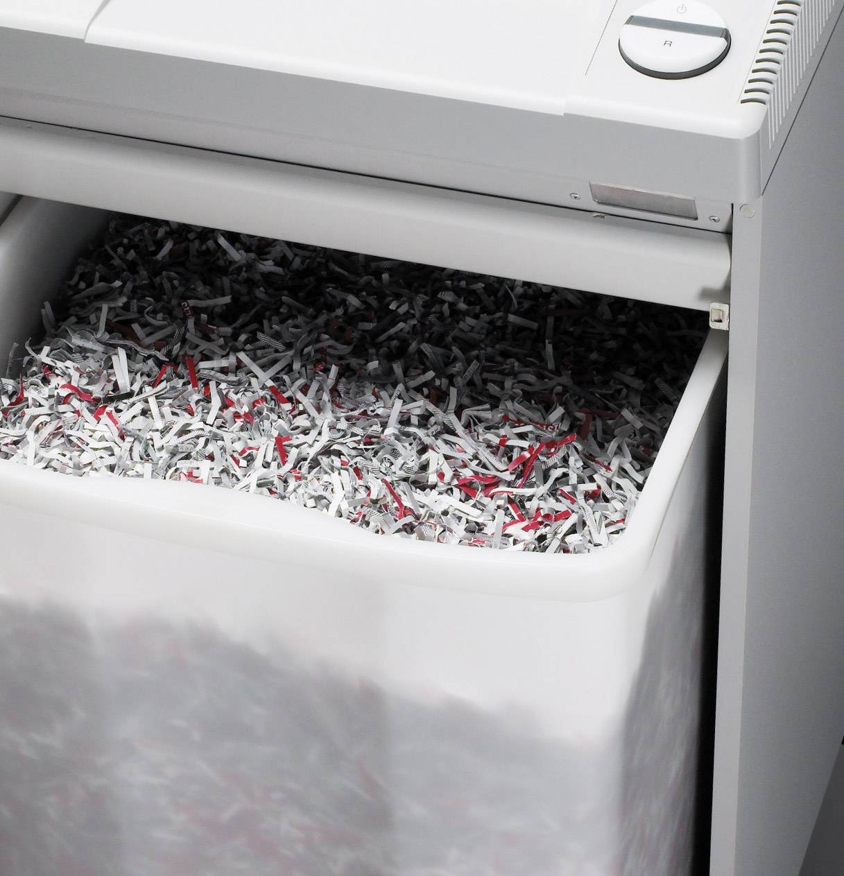 Een papiervernietiger met een opvangbak vol versnipperde papiersnippers.