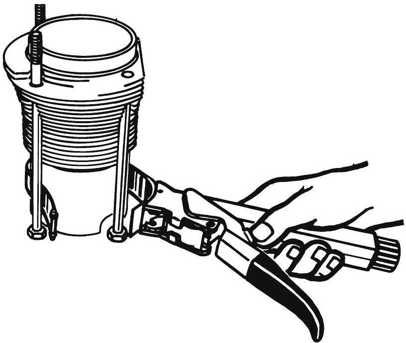 Een hand gebruikt een tang om een bout vast te draaien aan een cilindrisch object met ribben.