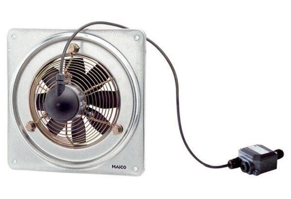 Industriële ventilator in metalen behuizing met zwart snoer, naast een kleine zwarte besturingsunit. Geschikt voor luchcirculatie.