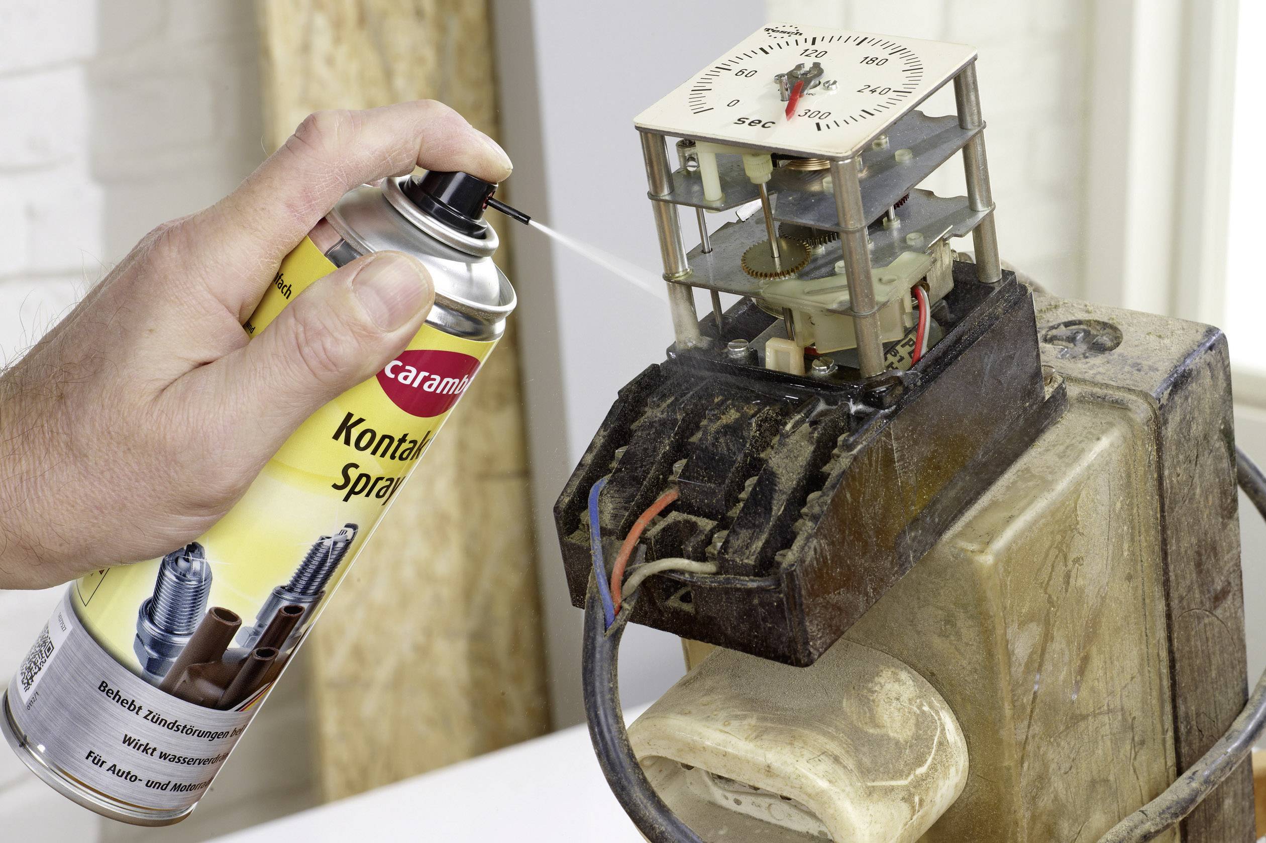 Hand spuit contactspray op elektronisch onderdeel met draden om elektrische contacten te reinigen. Het doel is het verbeteren van de geleidbaarheid.