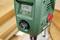 Groene boormachine van dichtbij. Het digitale display toont de snelheid '2490 tpm'. Links draaiknop en statusaanduidingen.