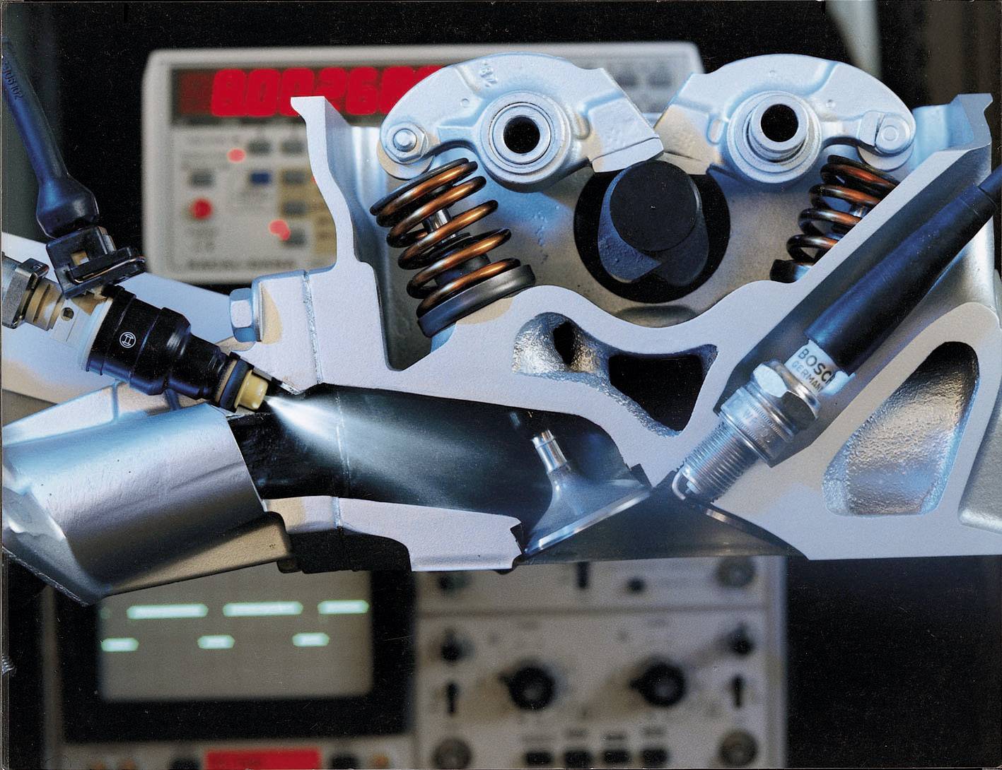 'Doorsnede van een automotor met zichtbare klepveren en bougies. Op de achtergrond zijn meetinstrumenten met rood oplichtende displays te zien.'