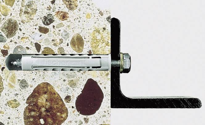 'Plug gemonteerd op een betonnen muur, links de structuur van het beton zichtbaar.'