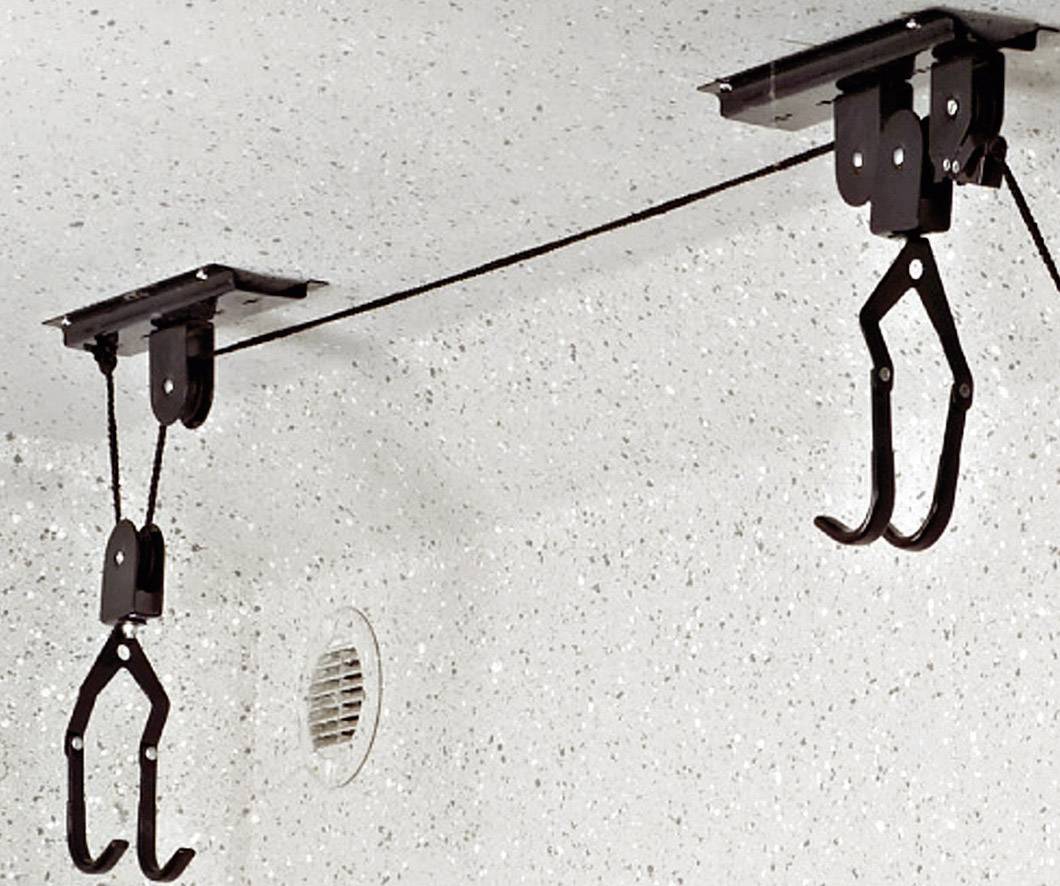Twee zwarte fietsophangbeugels aan het plafond gemonteerd, klaar om fietsen aan op te hangen, met een gespannen koord ertussen.