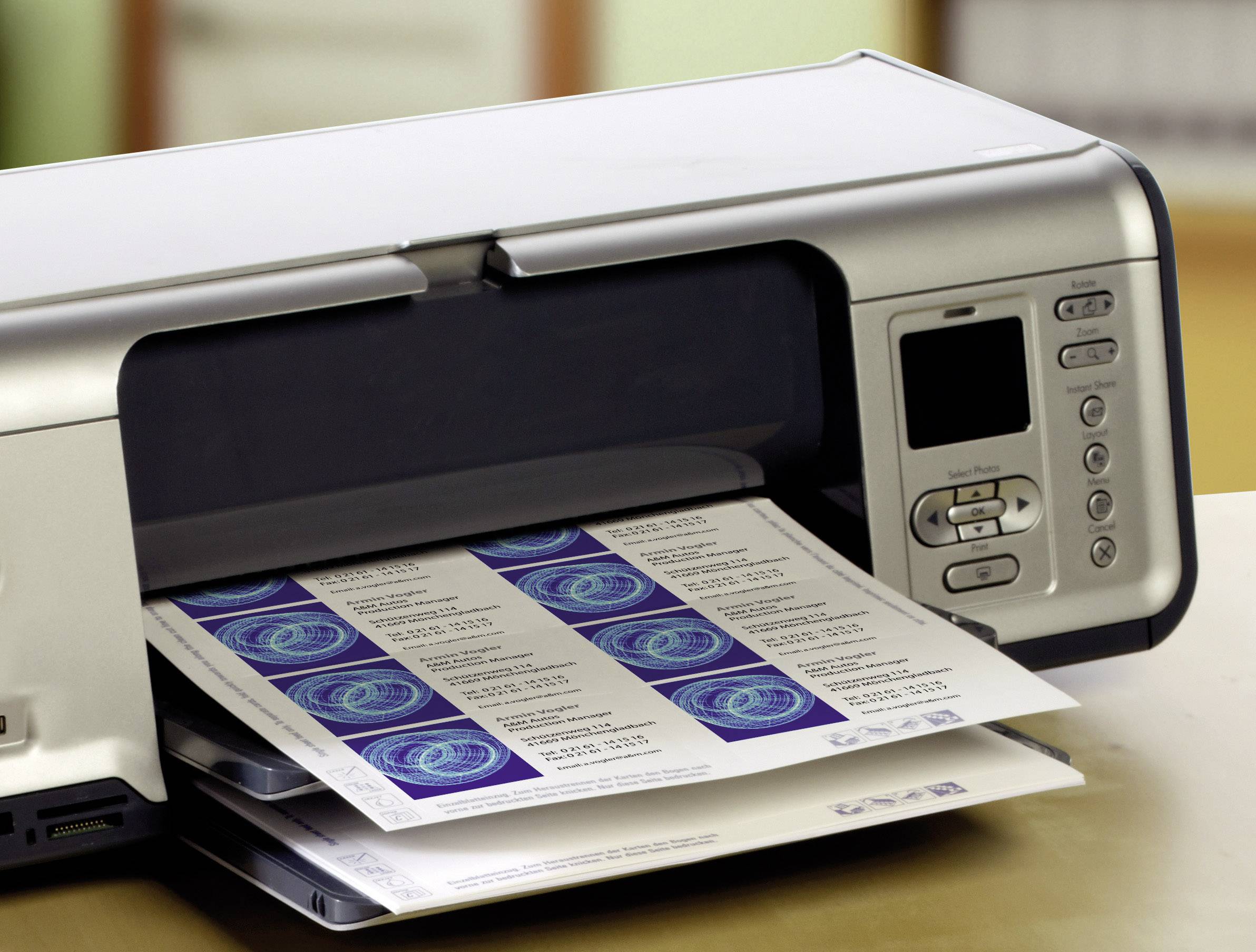 Een printer op een tafel geeft een vel met etiketten uit. Het display en de bedieningselementen zijn zichtbaar.