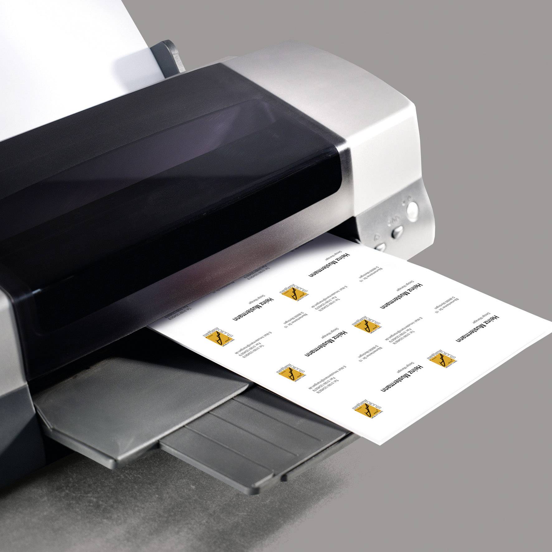 Een printer drukt een vel af met meermaals herhaald oranje grafisch ontwerp en tekst in kleine vakjes op wit papier.