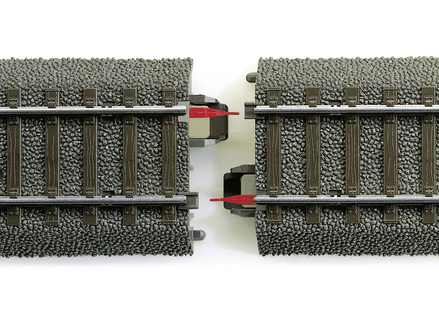 Modelarskie tory kolejowe z podwójnym połączeniem pośrodku; czerwone elementy łączące są wyróżnione.