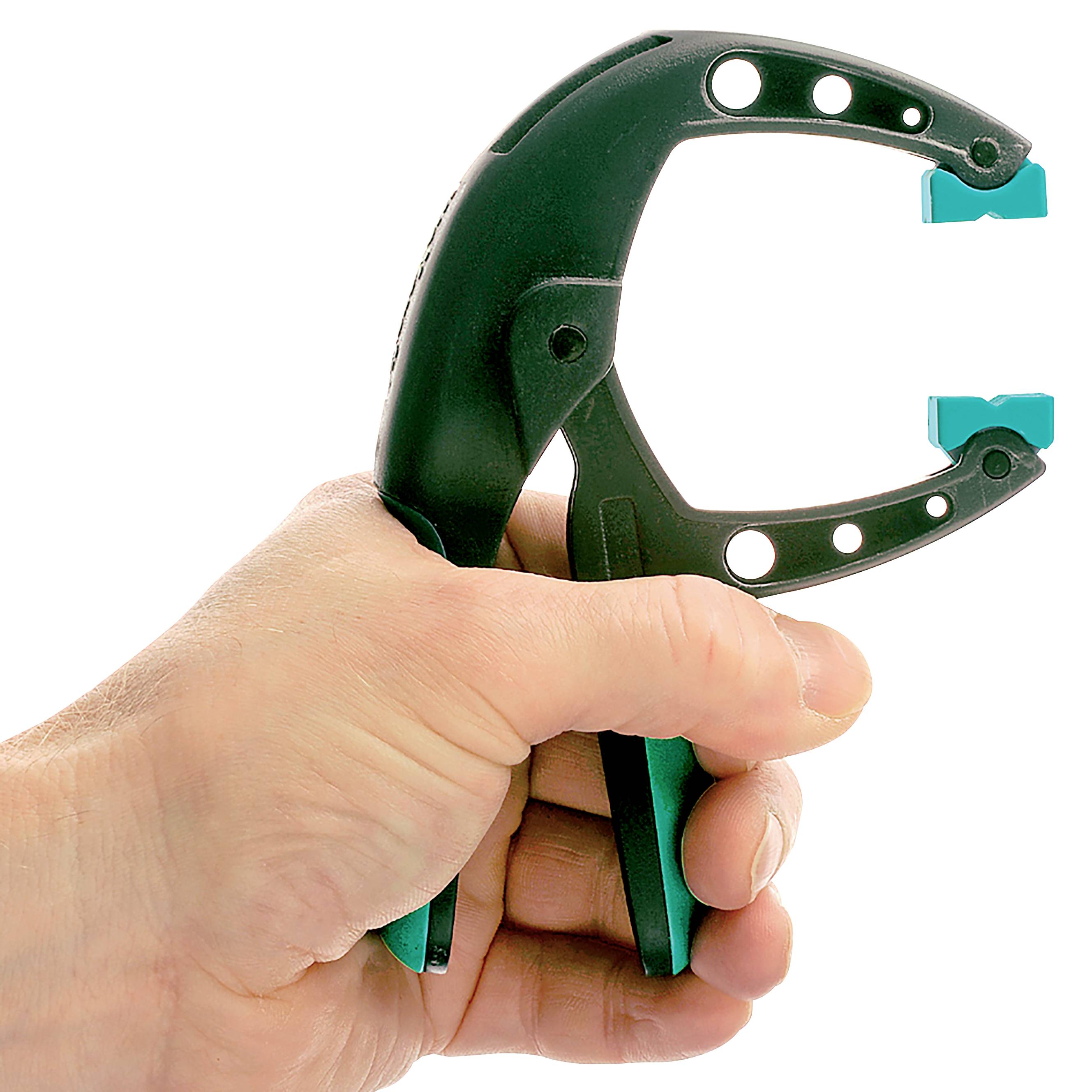 Jedna ręka trzyma czarny podnośnik do talerzy z niebieskim wkładem. Urządzenie służy do łatwego podnoszenia gorących talerzy.