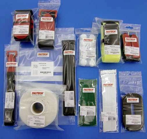 Różne opakowania materiałów mocujących marki Fastech na niebieskim tle, w tym opaski zaciskowe i elastyczne taśmy.