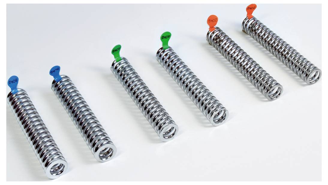 Sześć metalowych sprężyn z różnokolorowymi nasadkami (niebieska, zielona, pomarańczowa) stoi w rzędzie na białym tle.