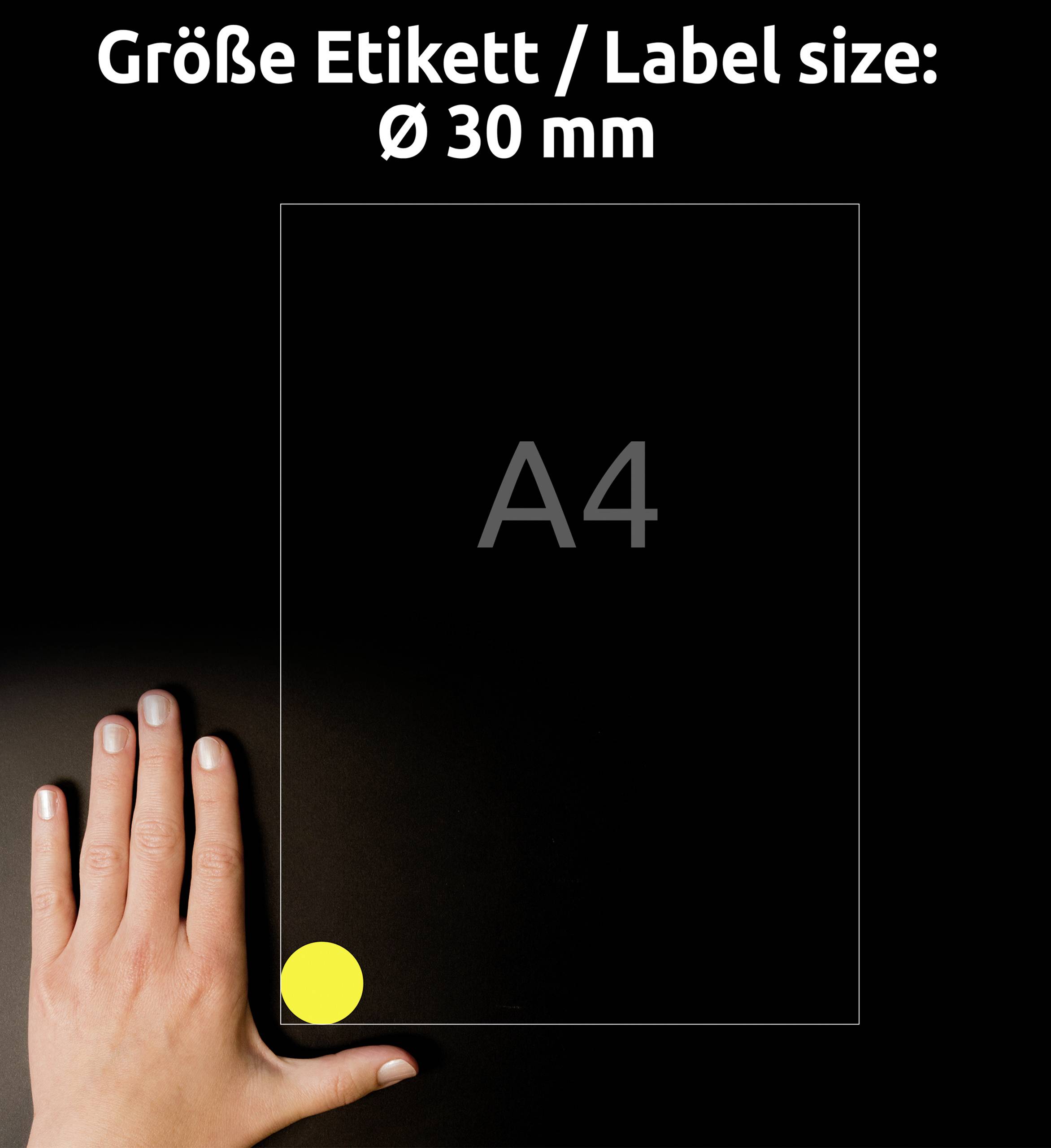 Rozmiar etykiety: średnica 30 mm. Dłoń wskazuje na żółtą etykietę na kartce formatu A4.
