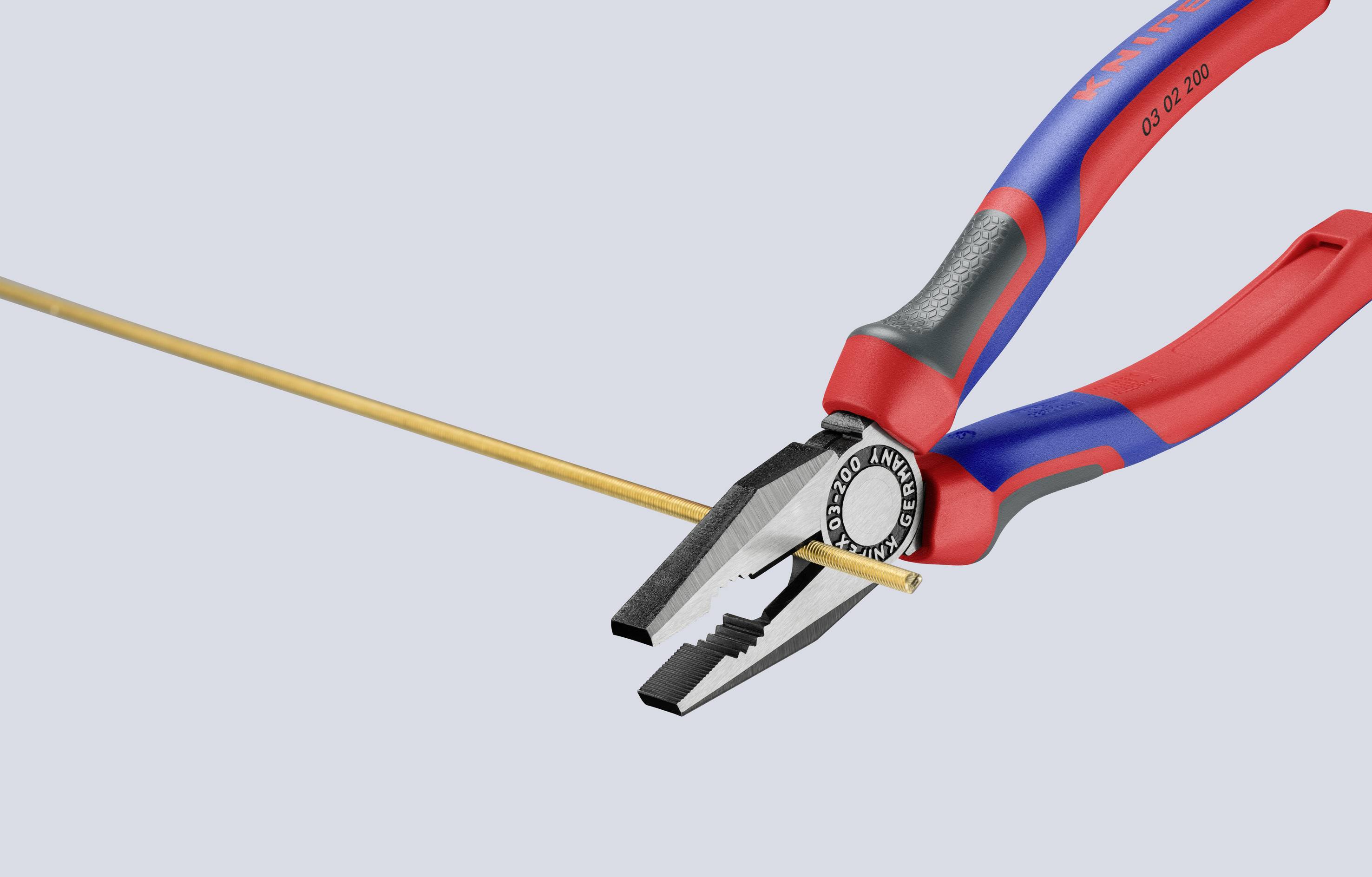 Szczypce przecinają pręt metalowy. Szczypce mają czerwone i niebieskie uchwyty i są przedstawione na jasnym tle.