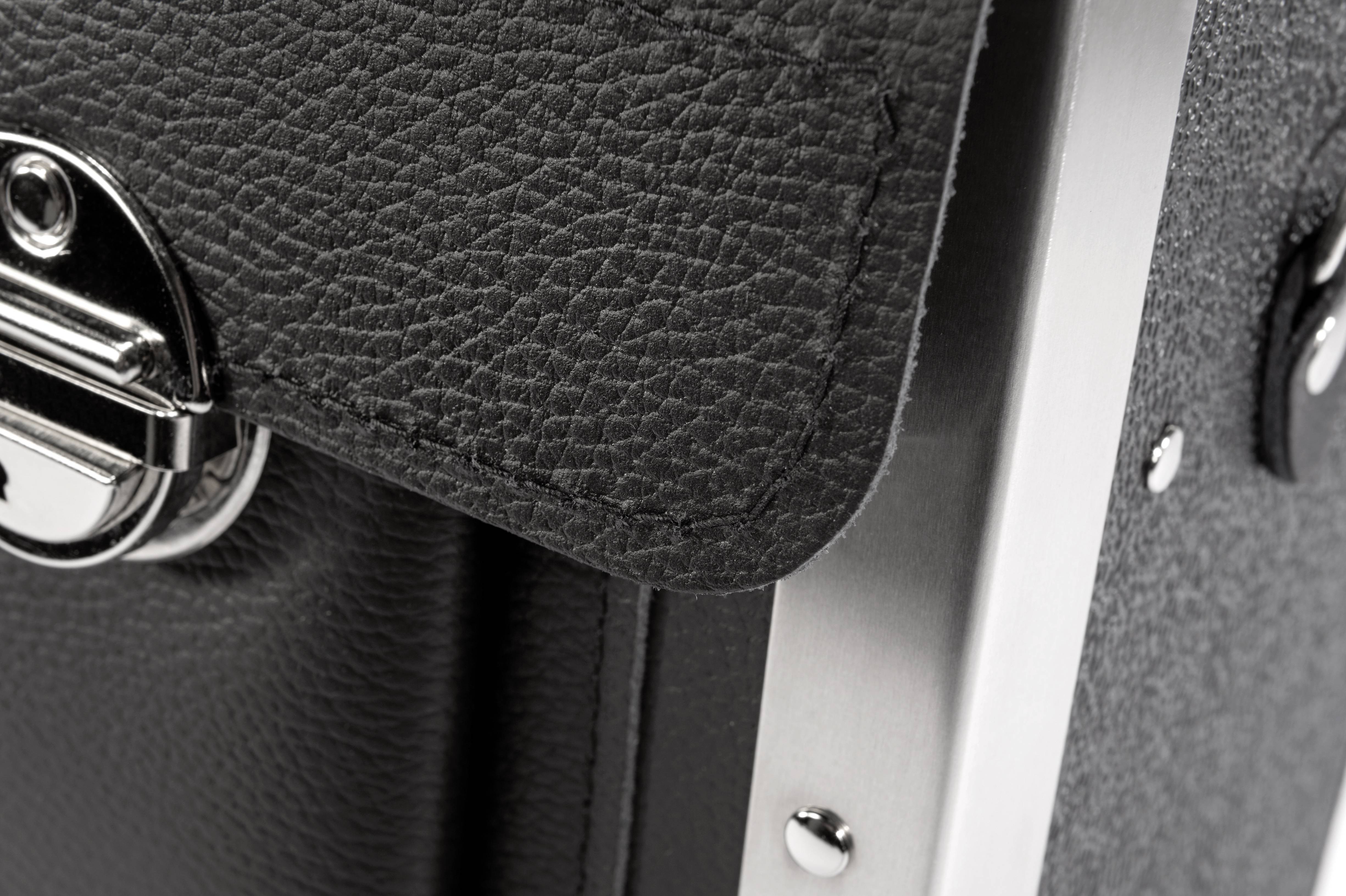 Zbliżenie czarnej, strukturowanej walizki skórzanej z srebrnymi elementami metalowymi i zamknięciem.