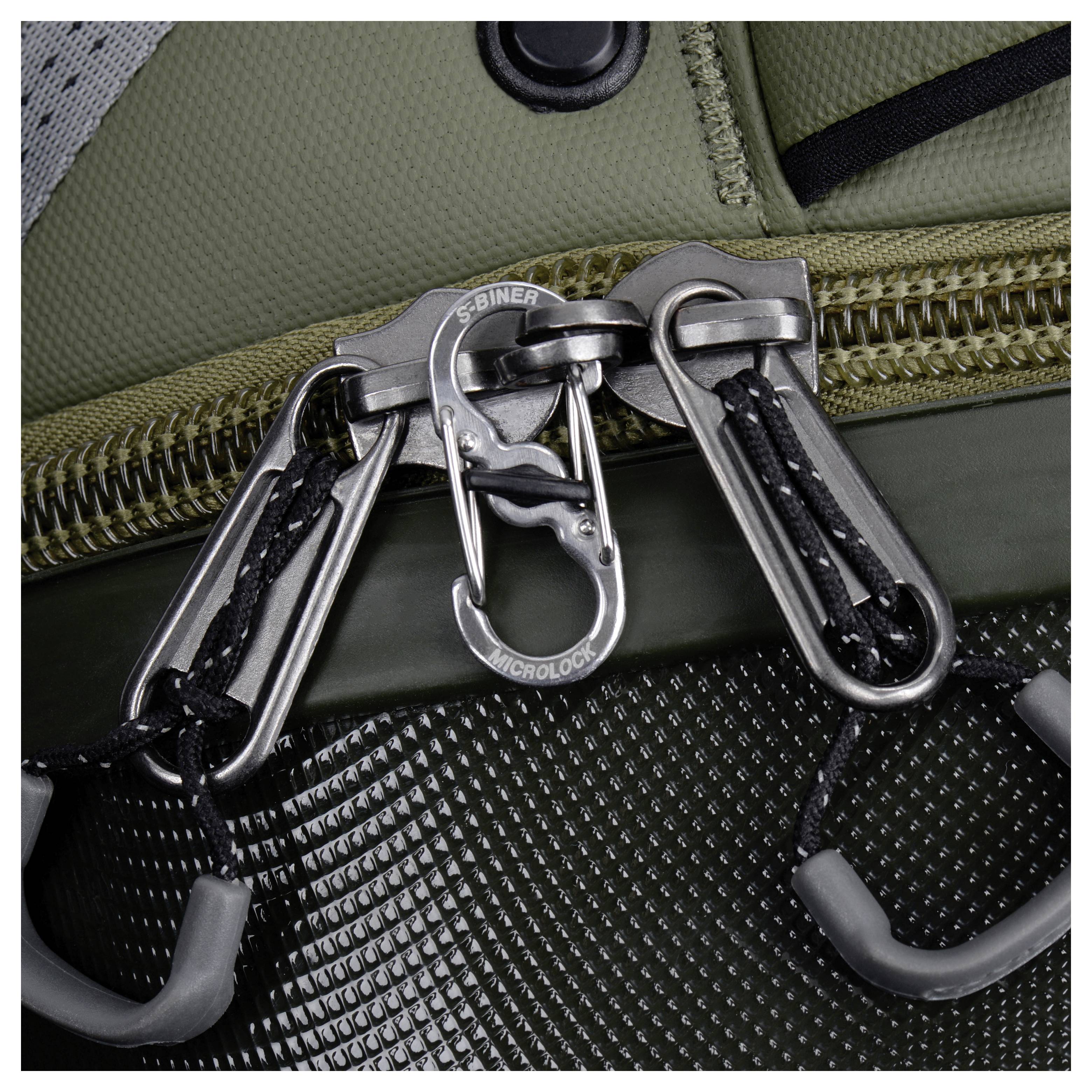 Zbliżenie metalowych elementów mocujących i karabińczyka S-biner na teksturowanej powierzchni w kolorach zielonym i czarnym, podkreślające solidne zamocowanie i bezpieczeństwo.