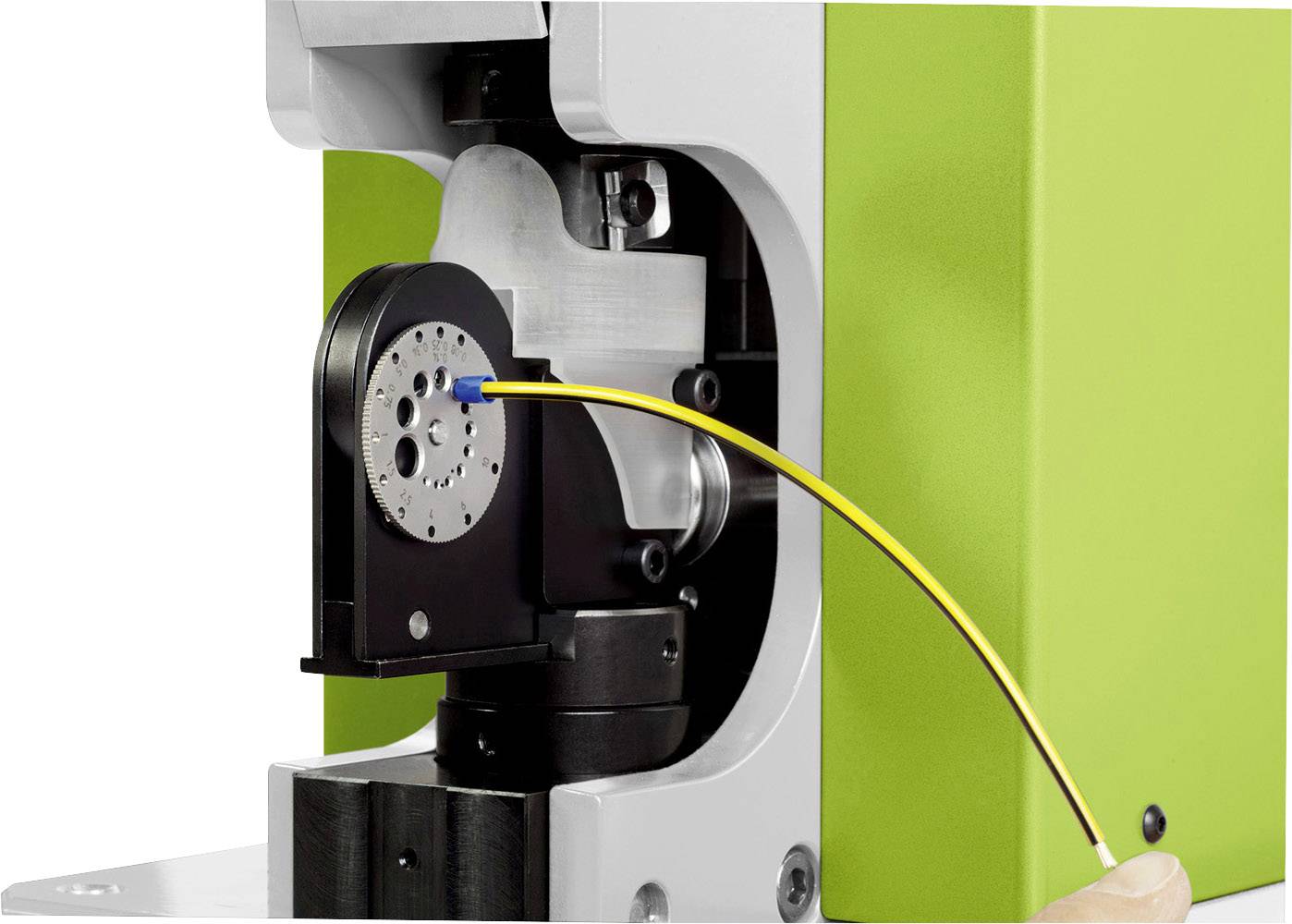 Zbliżenie maszyny z żółtym przewodem wprowadzanym do urządzenia cylindrycznego kształtu.