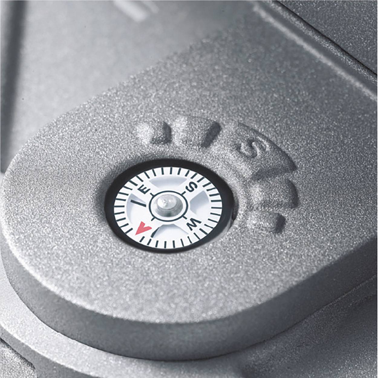 Zbliżenie kompasu na metalowej powierzchni, wskazującego na południowy zachód.