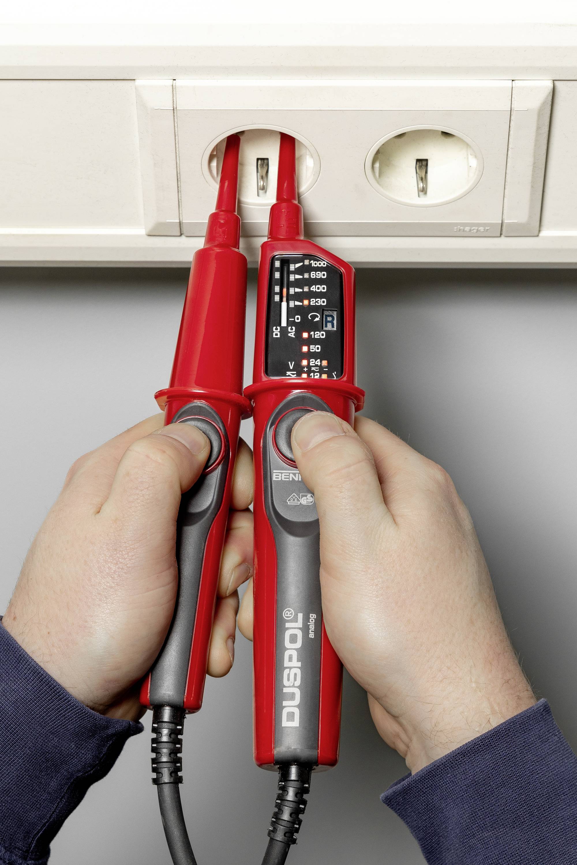 Jedna osoba trzyma tester napięcia w gniazdku elektrycznym. Tester napięcia wyświetla różne ustawienia napięcia.