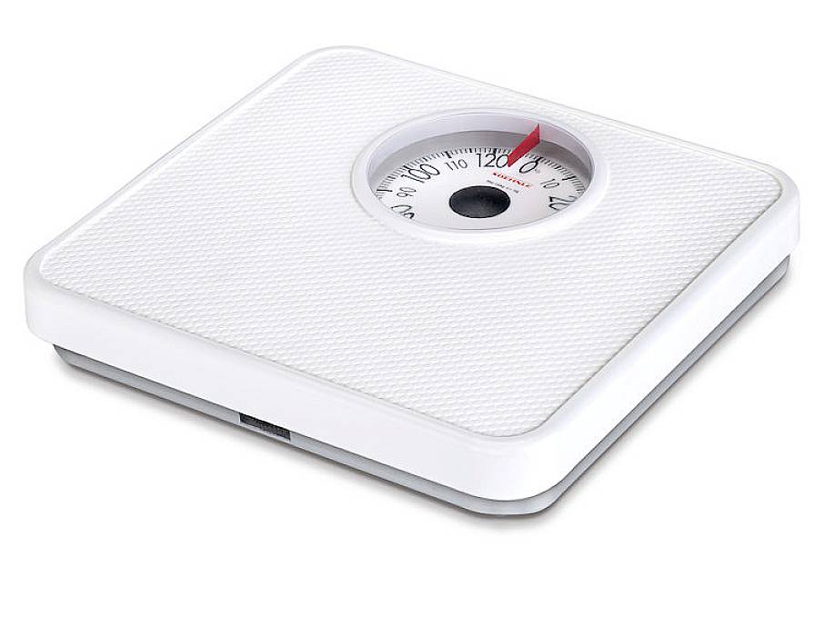 Biała analogowa waga łazienkowa wskazuje około 70 kilogramów.