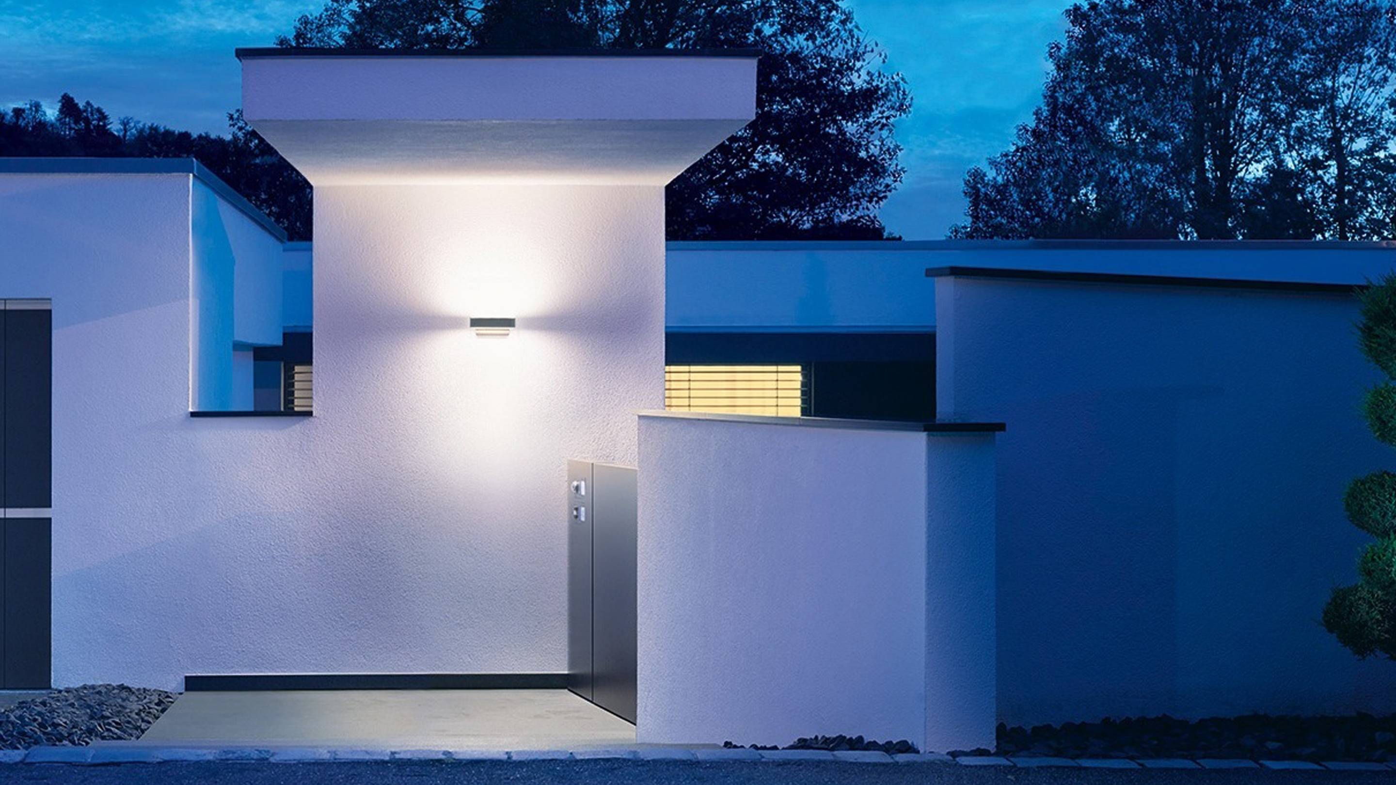 Oświetlony nowoczesny dom o zmierzchu, z geometrycznym designem i czystymi liniami.