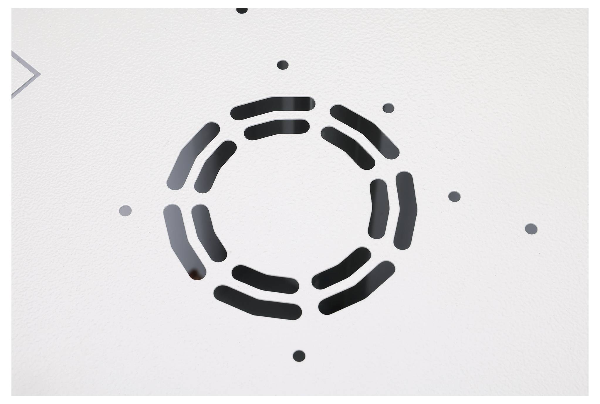 Biała powierzchnia charakteryzuje się wzorem czarnych, zakrzywionych linii tworzących kształt kołowy z dodatkowymi małymi kropkami wokół niego.