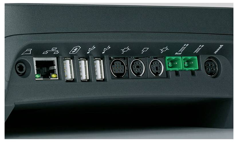 Widok z tyłu urządzenia technicznego z wieloma portami przyłączeniowymi, w tym USB, Ethernet oraz złączami, na szarym tle.