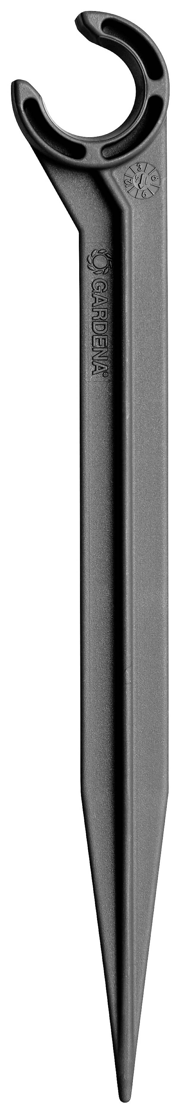 Czarny plastikowy szpilka gruntowa z otworem w kształcie litery C na końcu, przydatna do mocowania węży lub kabli w ziemi.