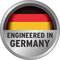 Okrągłe logo z napisem 'Engineered in Germany' na tle w kolorach flagi niemieckiej: czarnym, czerwonym i złotym.