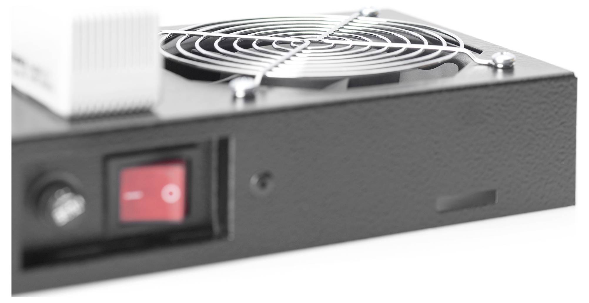 Zbliżenie czarnego urządzenia elektronicznego, przedstawiające czerwony przycisk zasilania i okrągły wentylator chłodzący z ochronną metalową kratką.