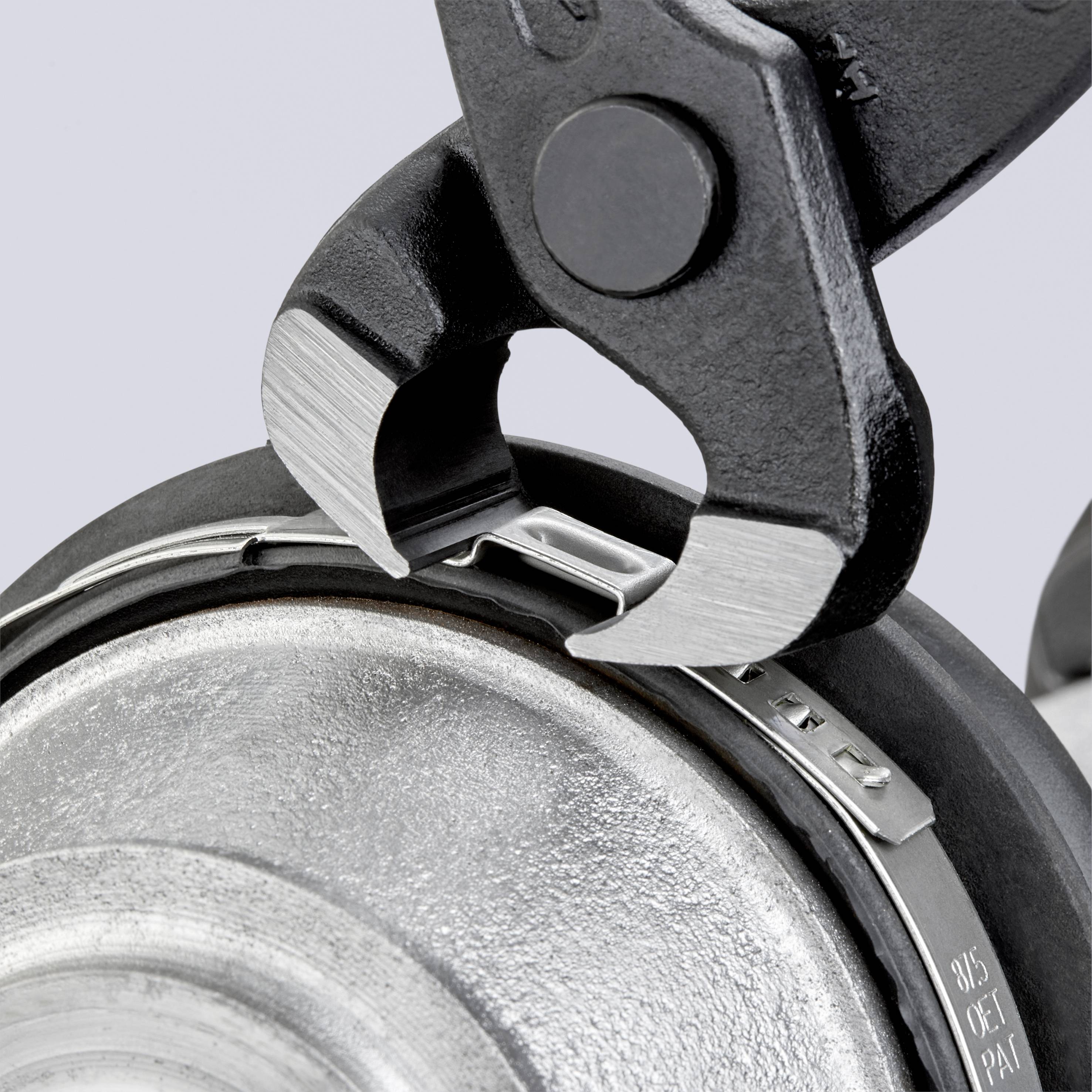 Zbliżenie klucza nastawnego, który obejmuje metalową powierzchnię. Fokus skupiony jest na szczegółach tekstury obu obiektów.