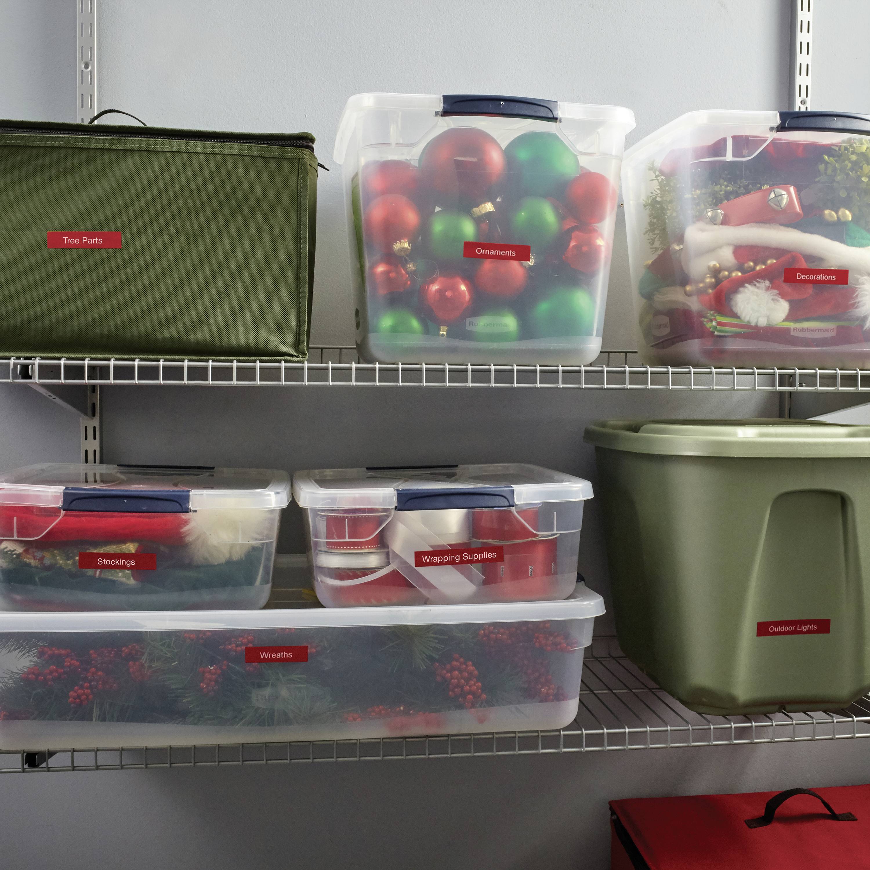 Plastikowe pojemniki na półkach z dekoracjami świątecznymi: pojemniki opisane jako 'Ozdoby', 'Skarpety' i 'Lampki zewnętrzne'.