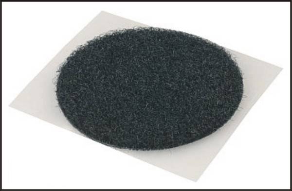 Czarny, okrągły filcowy ślizgacz na prostokątnej, białej kartce, przedstawiony w zbliżeniu.