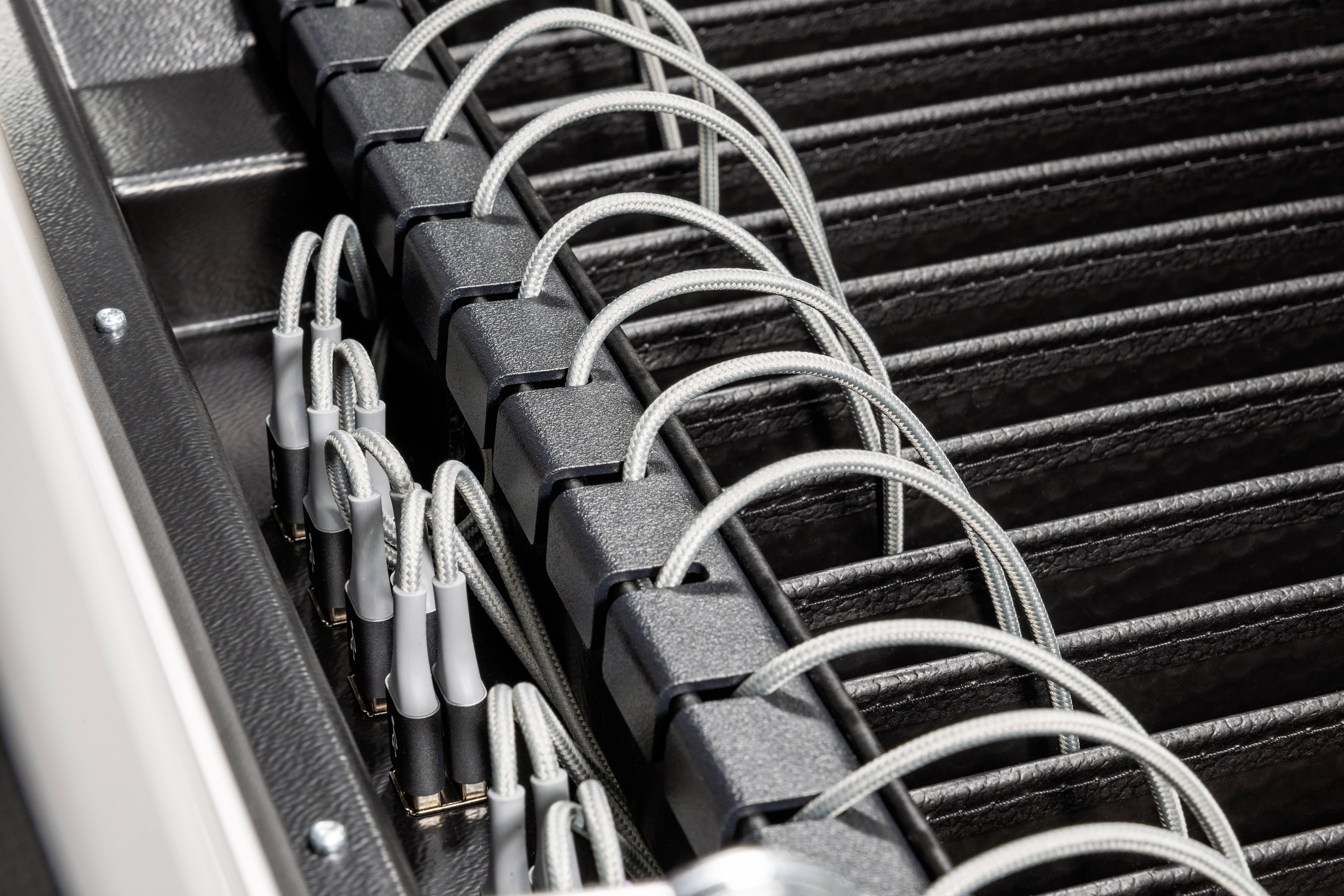 Kabel są ułożone w kanale kablowym. Kilka szarych kabli jest starannie poprowadzonych obok czarnych klipsów.