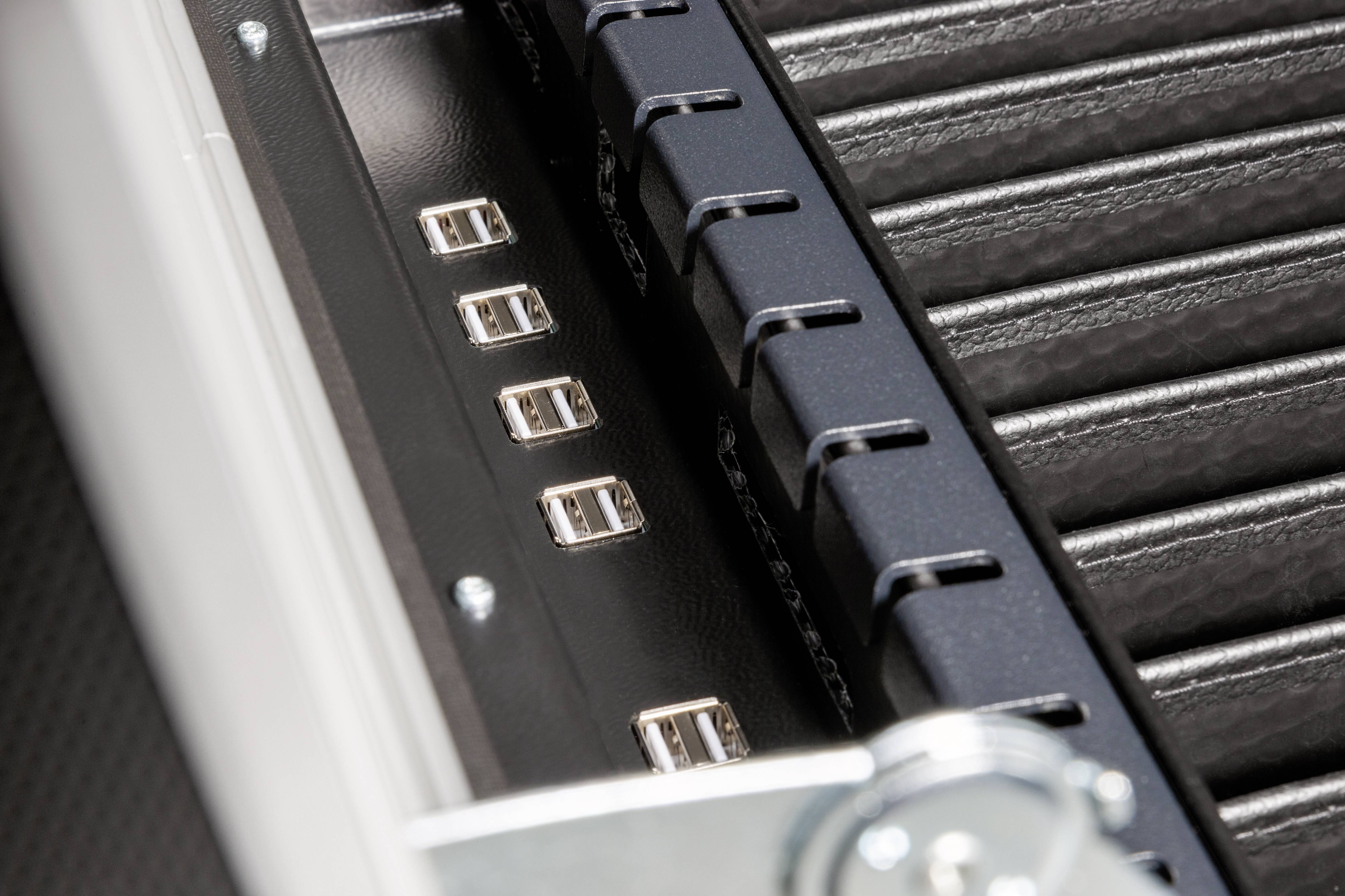 Zbliżenie złączy USB na obudowie komputera. Złącza są wmontowane w metalową ramkę, stanowiąc element infrastruktury informatycznej.