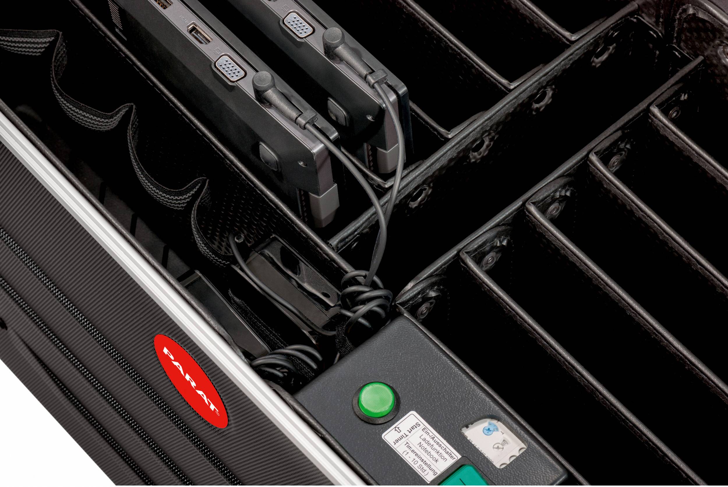 Walizka z przegrodami do przechowywania i ładowania laptopów, dwa urządzenia sąładowane. Widoczny jest zielony przycisk i kable.