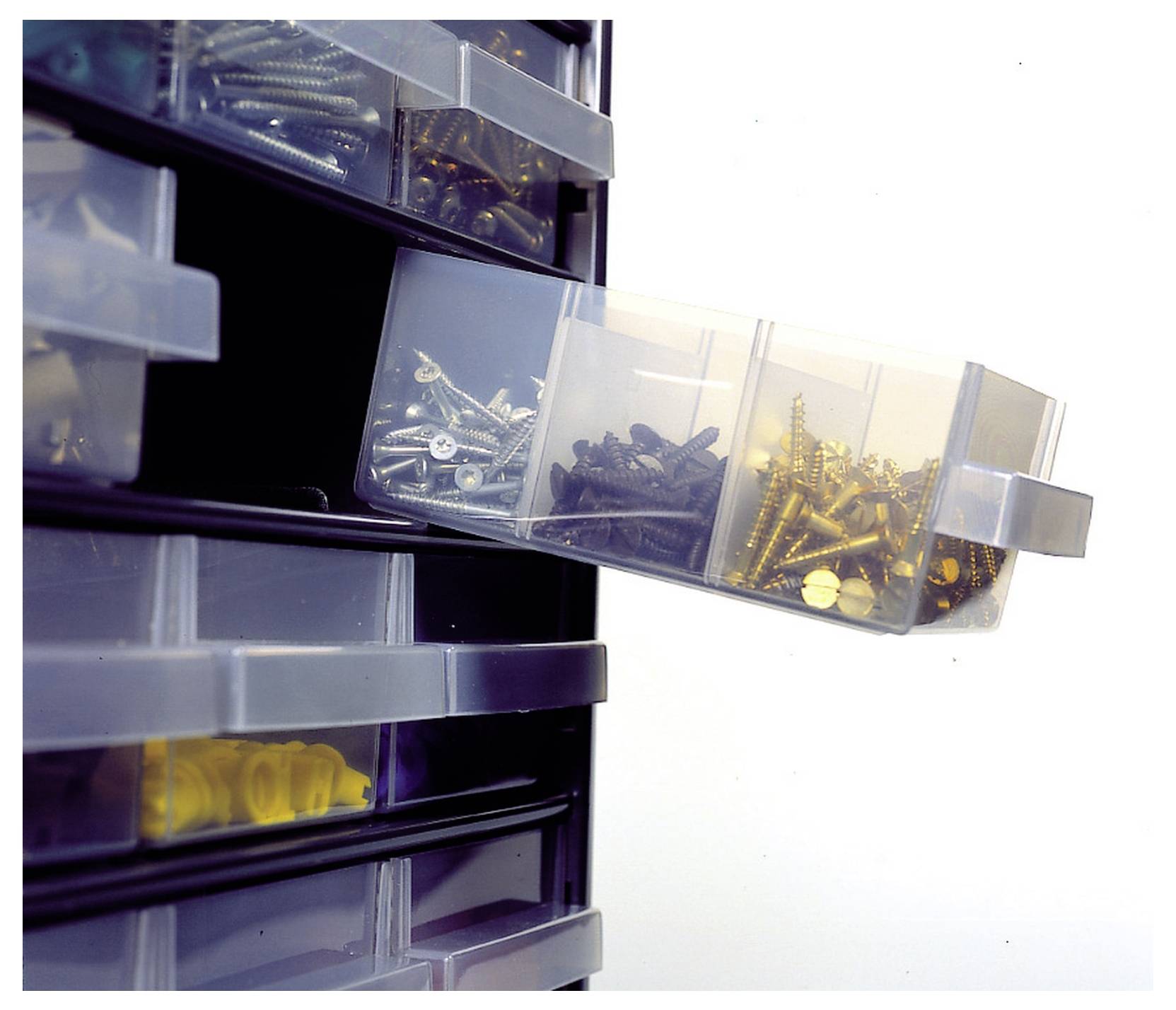 Przezroczystą szufladkę magazynową otwarto częściowo, odsłaniając różne rodzaje śrub ułożonych w oddzielnych przegródkach.