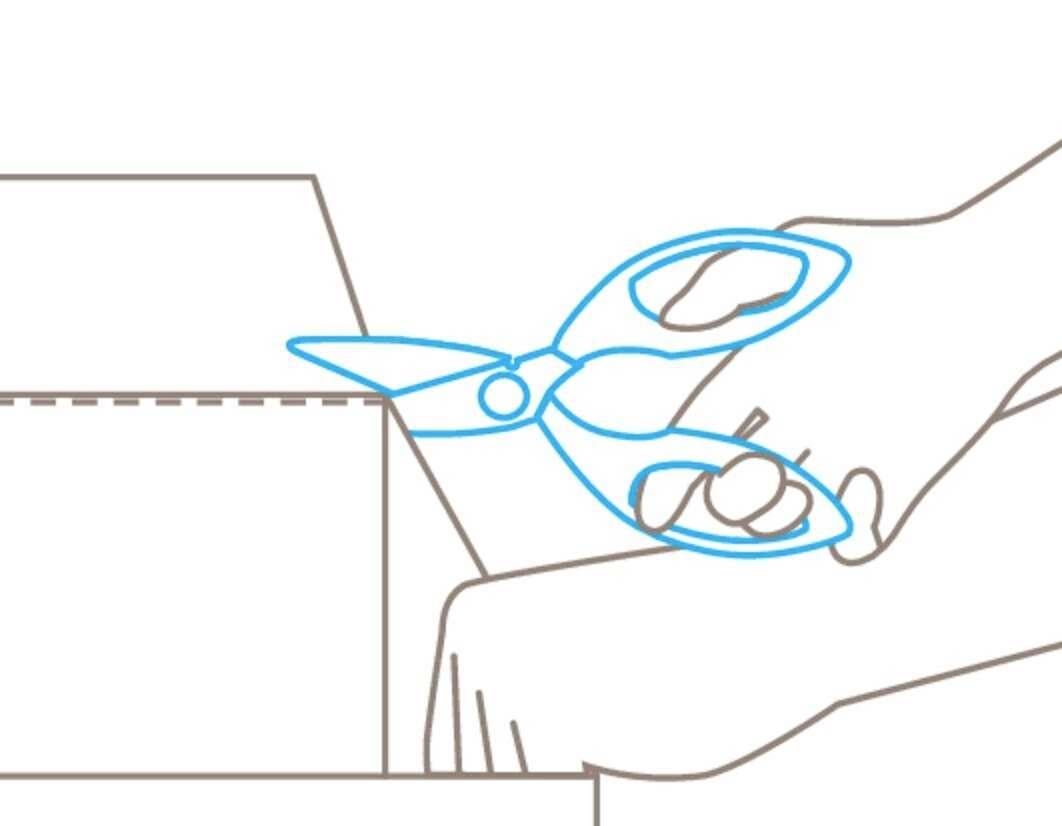 Ręka trzyma nożyczki i przycina karton wzdłuż linii przerywanej.
