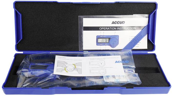 Cyfrowy suwmiarka w otwartym niebieskim etui z instrukcją i opakowaniem ochronnym, wyświetlacz LCD pokazujący aktualny pomiar.