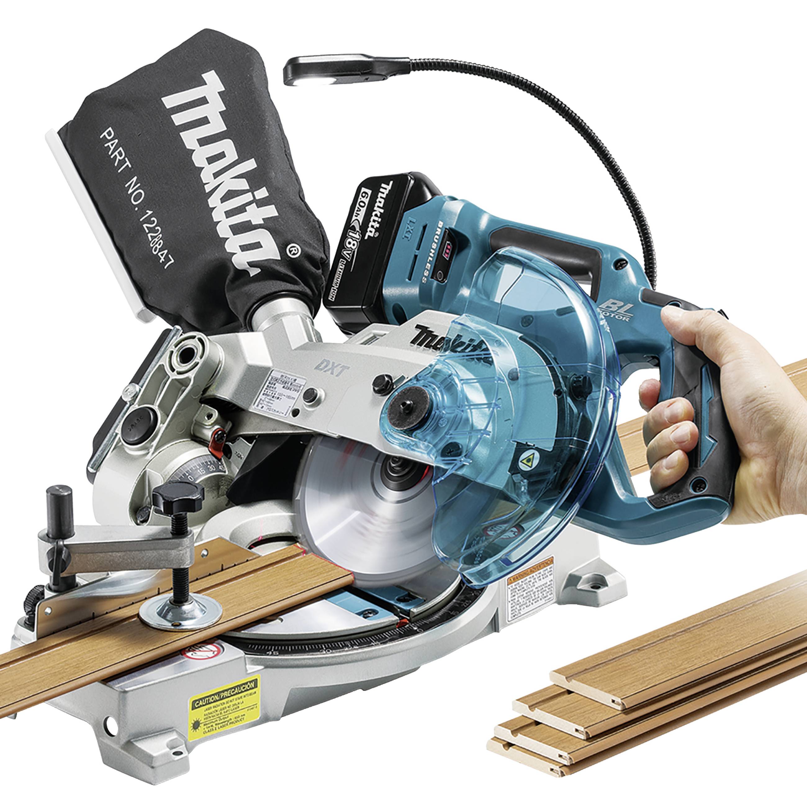 Jedna ręka trzyma piłę ukosową, która przecina deskę drewnianą. Maszyna jest niebieska i srebrna, z czarną rączką.