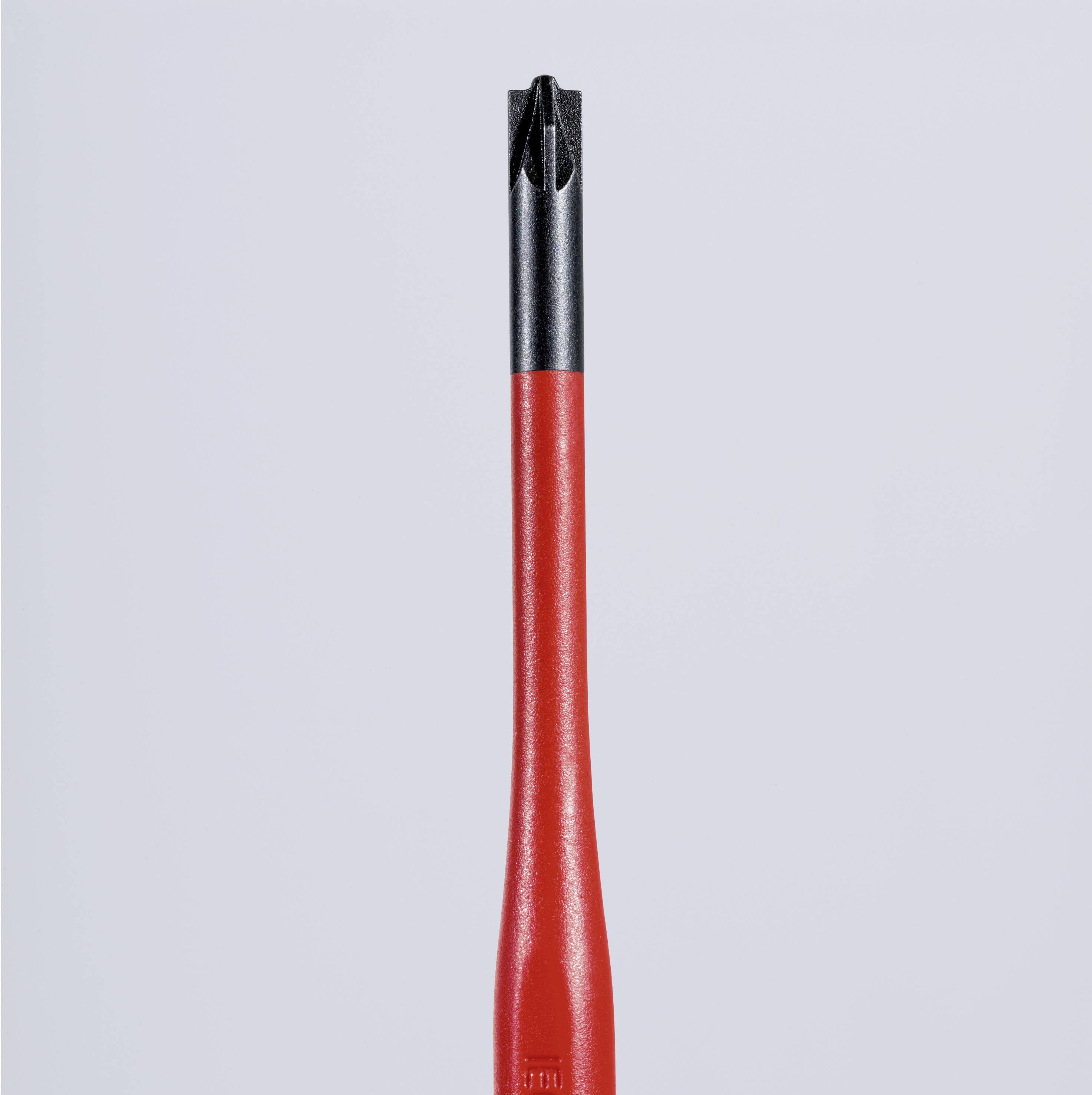 Czerwony śrubokręt z czarną końcówką na szarym tle.