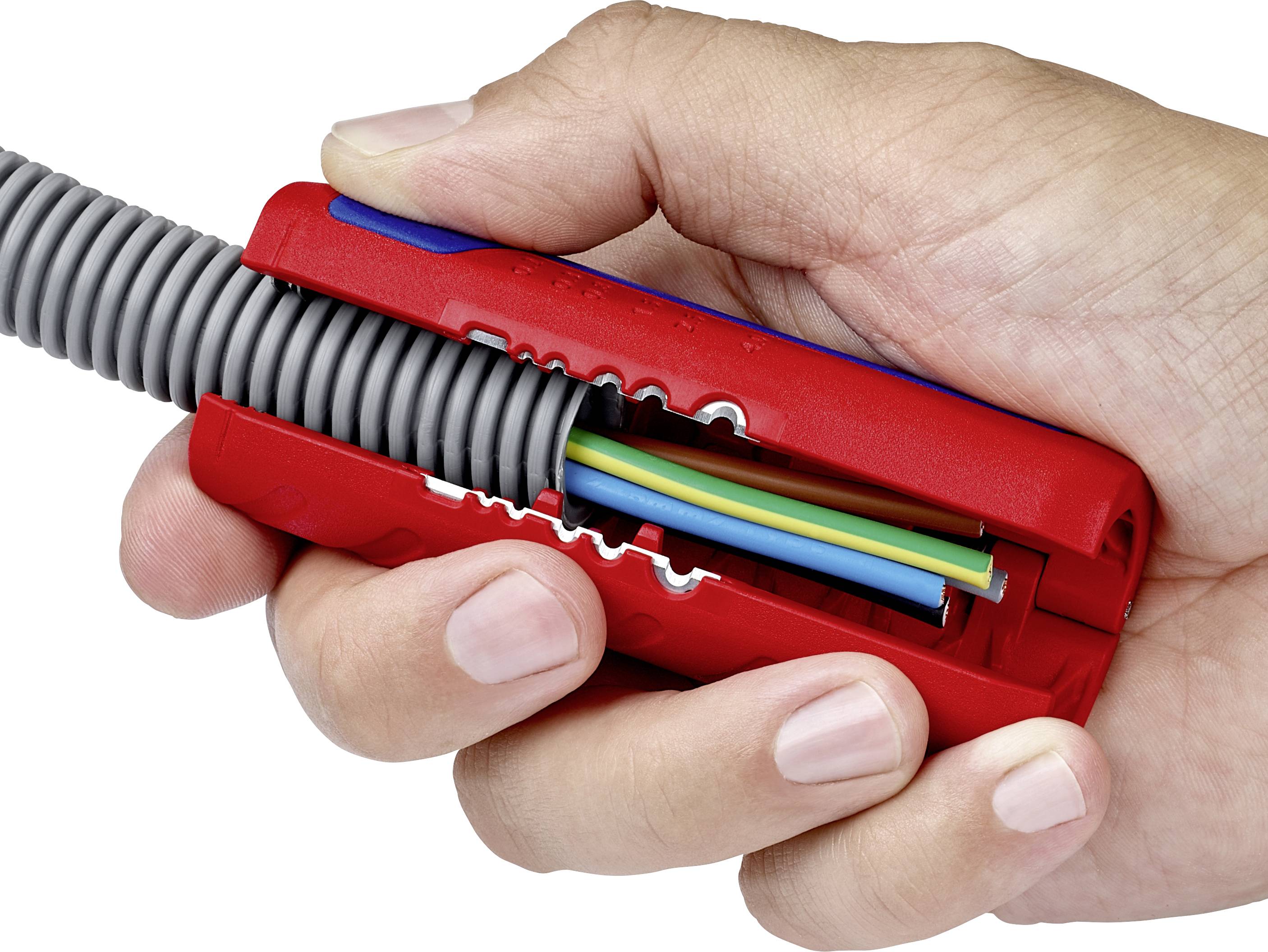 Jedna ręka trzyma czerwone narzędzie do zdejmowania izolacji z kabli, które sprawnie odsłania szary kabel z niebieskim, zielono-żółtym i czarnym przewodem wewnątrz.