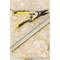 Nożyce ręczne na drewnianym stole, ułożone obok kawałka siatki drucianej i metalowego paska.